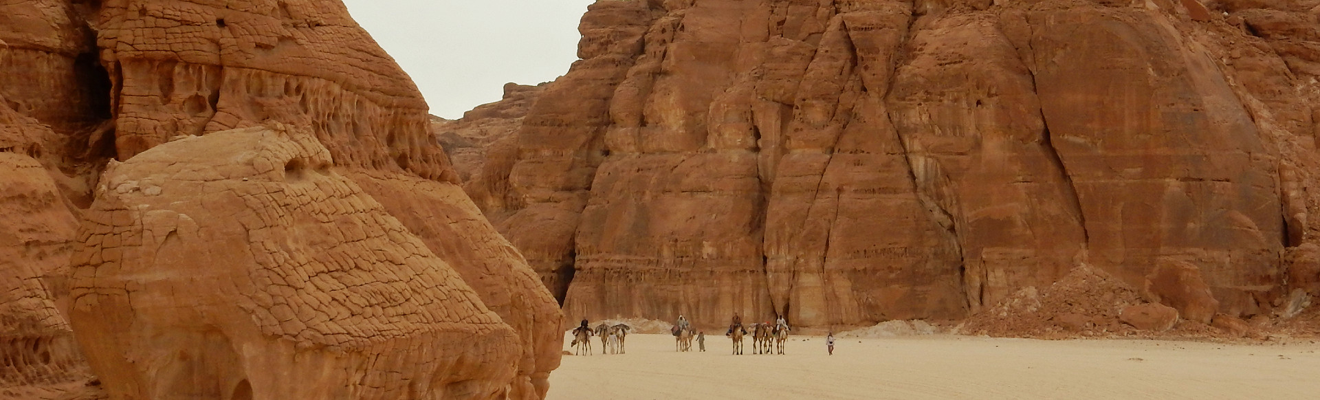 tussen twee zandstenen rotsformaties komt de karavaan van DesertJoy